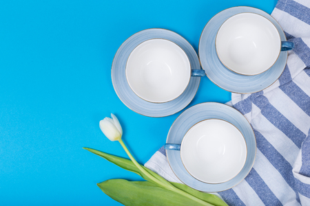 Empty plates and bowls on blue wooden background. Retro toned. Top view with copy spaceの写真素材
