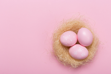 Pink easter eggs in nest on pastel color background with space. Conceptの写真素材