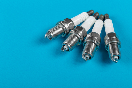 A set of new spark plugs a blue background. Studio macro image of high quality. To advertise auto service.の写真素材