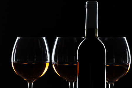 elegant wine bottles and wine glass in a black backgroundの写真素材