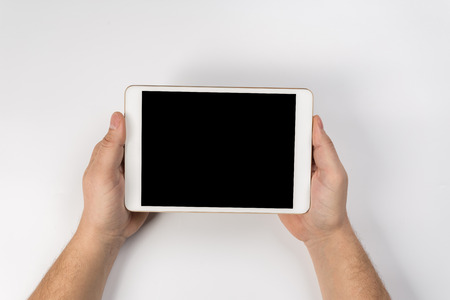Hand touch on empty screen of tablet above brown table top view, Leave space for display of your content, Technology concept, mock up for montage your contentの写真素材