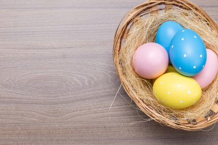 Easter eggs in the basket on wooden backgroundの写真素材