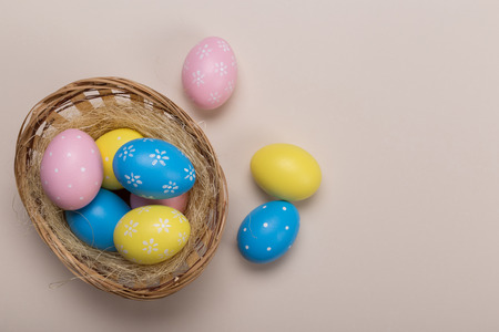 Colorfull easter eggs in nest on pastel color background with space. Conceptの写真素材