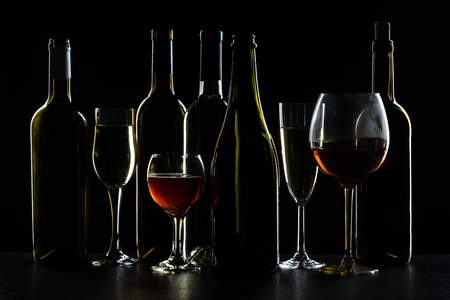 Bar Concept with a Wine Bottle, a Wine Glass and a Cocktail on a Black Backgroundの写真素材