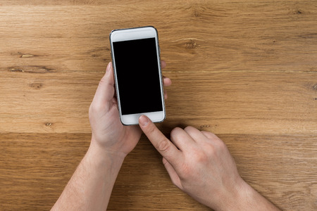 hand using phone white screen on top viewの写真素材