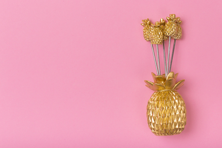 golden pineapple capas on pastel pink backgroundの写真素材