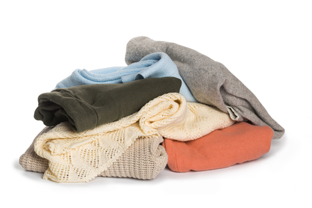 Stack of various sweaters isolated on white backgroundの写真素材