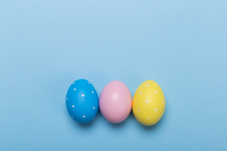 Colorfull easter eggs in nest on blue pastel color background with space.の写真素材