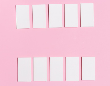 Blank white business cards on pink background. Mockup for branding identity. Template for graphic designers portfolios. Top view.の写真素材