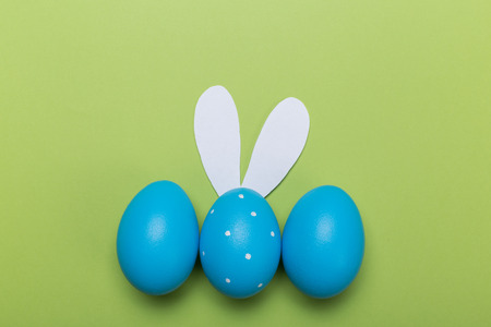 blue easter eggs in nest on green pastel color background with space.の写真素材