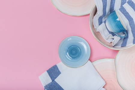 Empty plates and bowls on pink background. Top view with copy spaceの写真素材