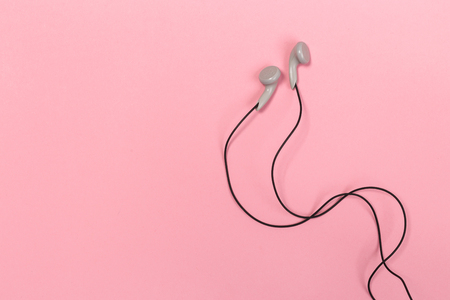 Headphones on pastel background. White headphones on a pink background. Top view. Flat lay. Copy space. Trendy colorful photo. Minimal style with colorful paper backdrop. Music conceptの写真素材