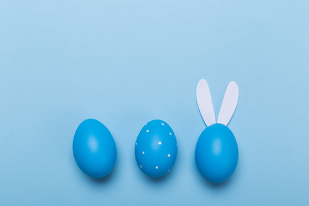 Blue easter eggs in nest on pastel color background with space.の写真素材