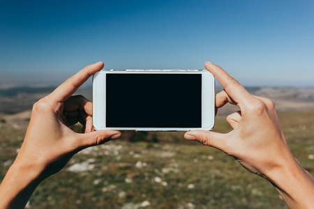 Close up of a woman using mobile smart phone outdoorの写真素材