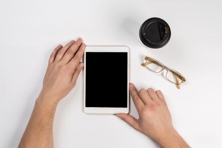 Hand touch on empty screen of tablet above brown table top view, Leave space for display of your content, Technology concept, mock up for montage your contentの写真素材