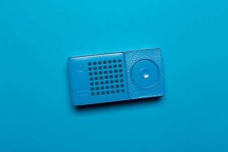Retro radio receiver on a blue pastel background. Media technology 60s. Top view.