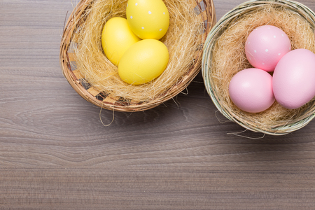 Easter eggs in the basket on wooden backgroundの写真素材