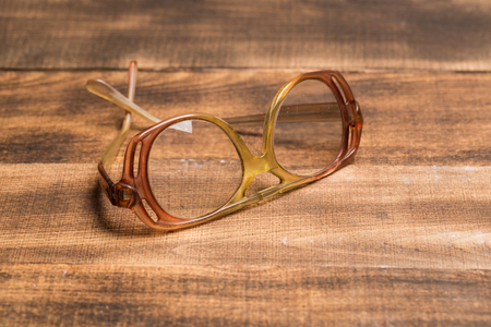 A pair of glasses on a wooden tableの写真素材