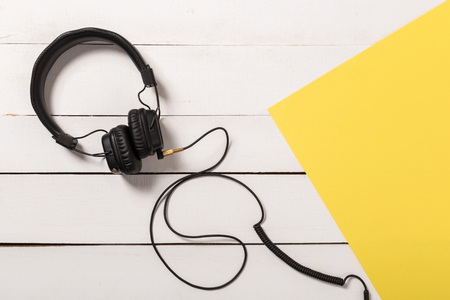 Headphones  on wooden background.Trendy colorful photo. Minimal style with colorful paper backdrop. Music conceptの写真素材