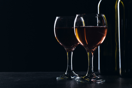 elegant wine bottles and wine glass in a black backgroundの写真素材