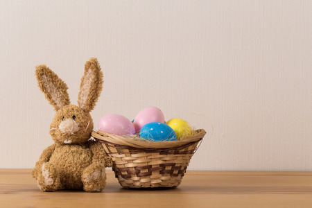 Easter bunny rabbit with  painted egg on wooden background. Easter holiday concept.の写真素材