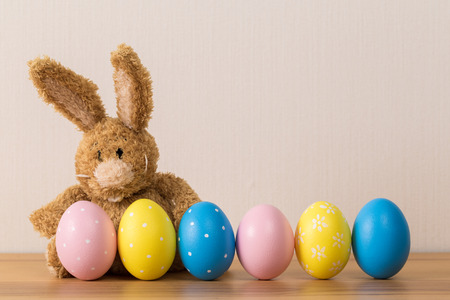 Easter bunny rabbit with  painted egg on wooden background. Easter holiday concept.の写真素材