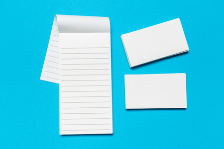 Blank white business cards on blue background. Mockup for branding identity. Template for graphic designers portfolios. Top view.の写真素材