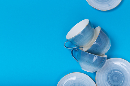 Clean dishes, coffee or tea set. Plenty of elegant porcelain cups and saucers with flower inside at white background, high key, top view and flat lay.の写真素材