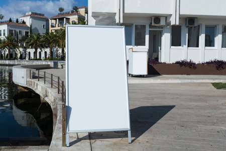 Blank white outdoor advertising stand, sandwich board mock up template. Clear street signage board placed inside modern building. Urban city, shopping center environmentのeditorial素材