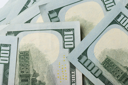 American dollars. A stack of hundred dollar bills. Close up of new hundred dollar bill on the white...