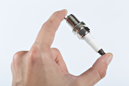 New spark plug in hand on a white backgroundの写真素材