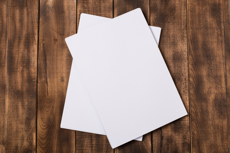 Blank paper notebook on brown wooden table background. Top view with copy spaceの写真素材
