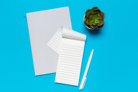Blank paper notebook on blue background.Office desk table concept.の写真素材