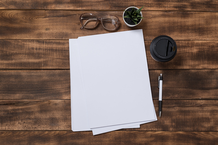 top view image of open notebook with blank pages next to cup of coffee on wooden table. ready for adding text or mockup.の写真素材