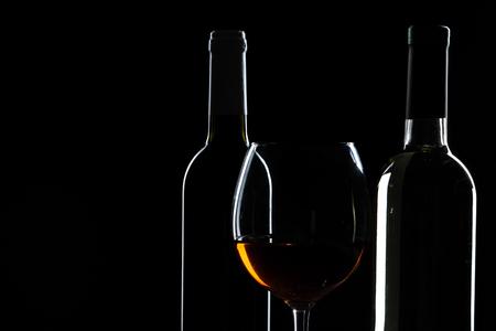 elegant wine bottles and wine glass in a black backgroundの写真素材