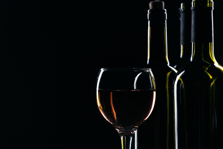 elegant wine bottles and wine glass in a black backgroundの写真素材
