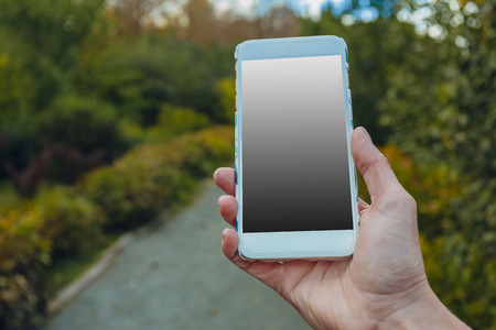 Closeup of female hand using a smart phone in parkの写真素材
