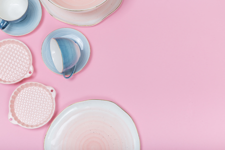 Empty plates and bowls on pink background. Top view with copy spaceの写真素材