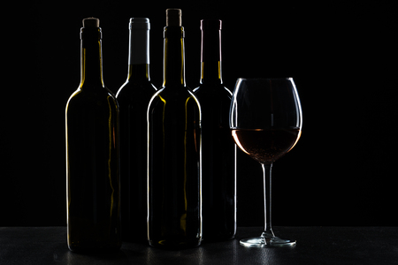 Bar Concept with a Wine Bottle, a Wine Glass and a Cocktail on a Black Backgroundの写真素材