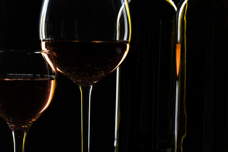 Bar Concept with a Wine Bottle, a Wine Glass and a Cocktail on a Black Backgroundの写真素材
