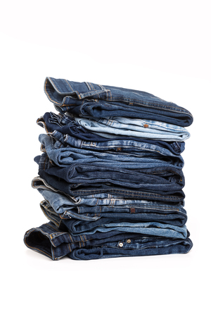 A stack of clothes jeans pants on a white background. Isolationの写真素材