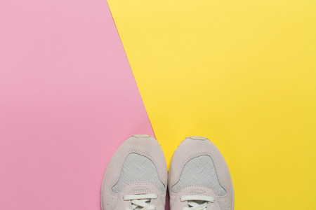 Overhead Shot Of White Sneakers On paper Pink Background