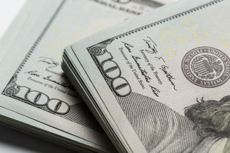 American dollars. A stack of hundred dollar bills. Close up of new hundred dollar bill on the white...