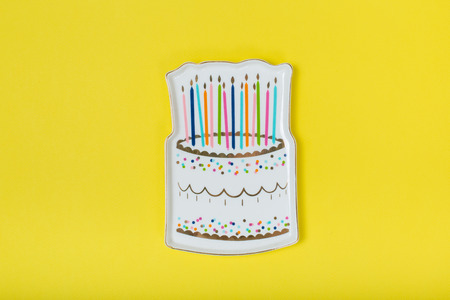 cake plate with candles on a yellow backgroundの写真素材