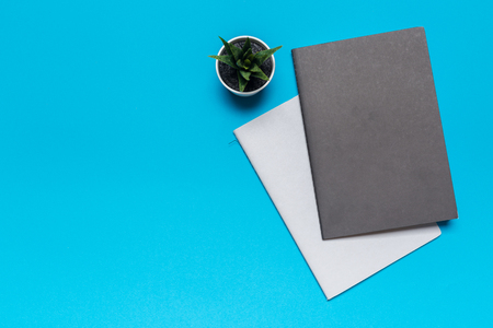 Blank paper notebook on blue background.Office desk table concept.の写真素材