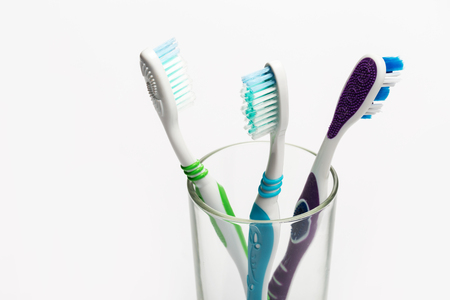Set of colorful toothbrushes in glass on white background.の写真素材