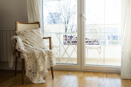 Vintage armchair against white wall and big window with curtain. Space for your copyの写真素材