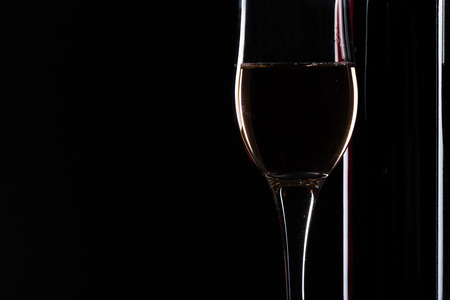 elegant wine bottles and wine glass in a black backgroundの写真素材