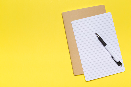 school notebook on a yellow background, notepad on a table.Top viewの写真素材