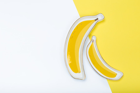 banana-like plate on yellow background. conceptの写真素材